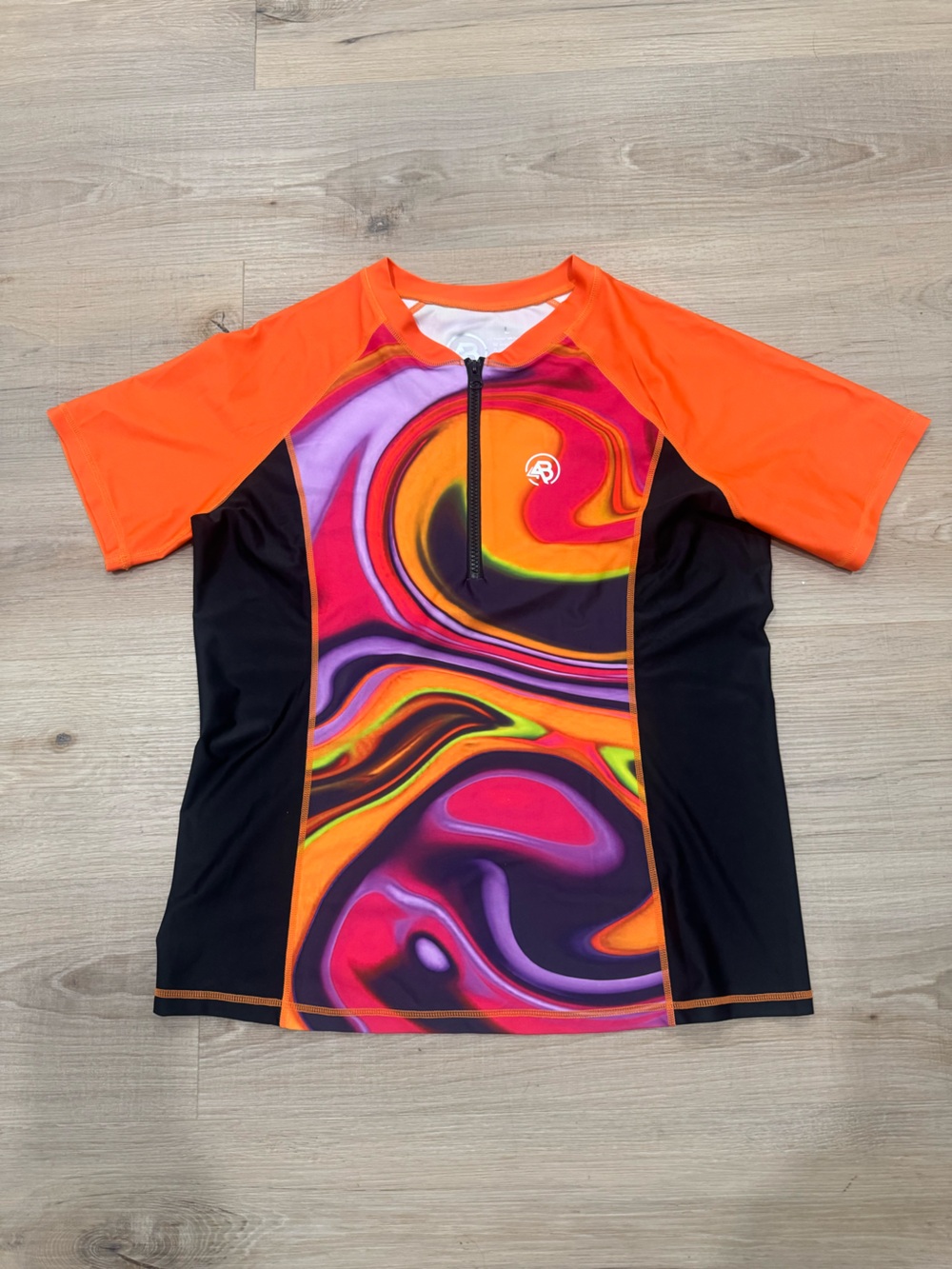 Neon Swirl Short Sleeve swim top. Orange, Purple, Black